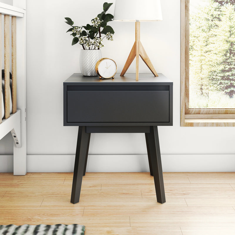 Modern black nightstand with wooden tripod lamp, white textured vase with greenery and gold clock by window, Scandinavian bedroom decor