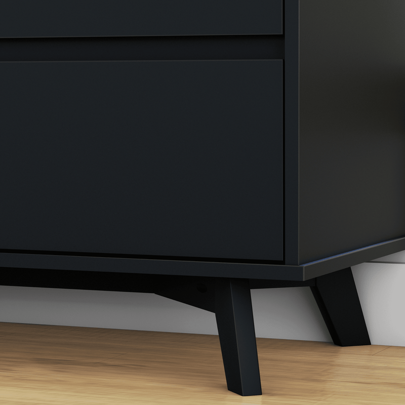 Close-up of matte black mid-century modern dresser cabinet with angled legs on hardwood floor, Scandinavian bedroom furniture design