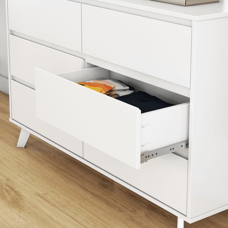 White modern dresser with open drawer revealing folded clothes on hardwood floor — minimalist bedroom storage chest of drawers