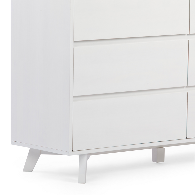Close-up of a white modern dresser with flat drawer fronts and mid-century angled legs — minimalist Scandinavian bedroom storage cabinet.