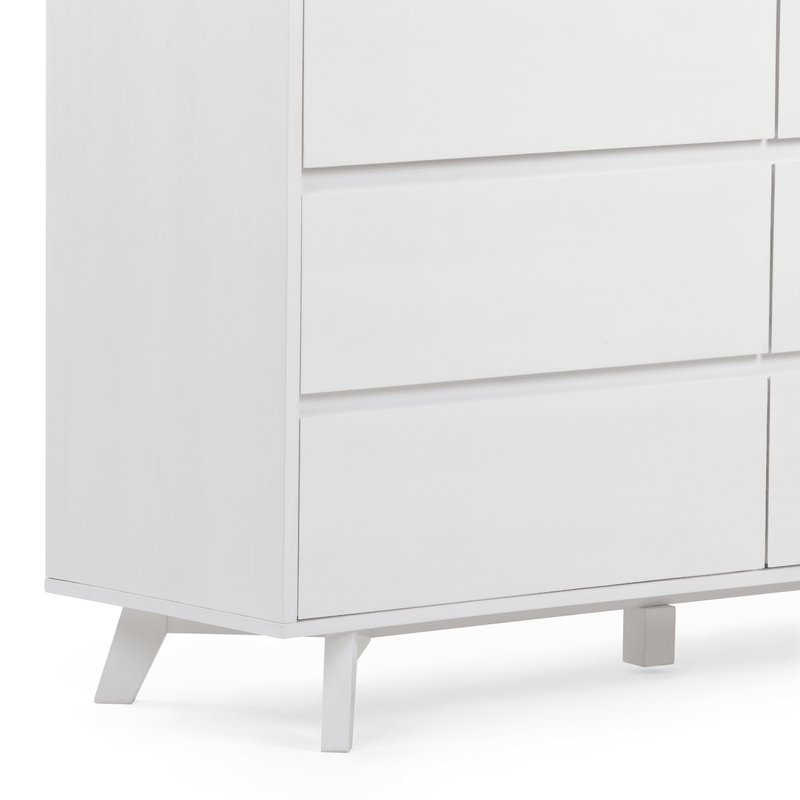 Close-up of a white modern dresser with flat drawer fronts and mid-century angled legs — minimalist Scandinavian bedroom storage cabinet.