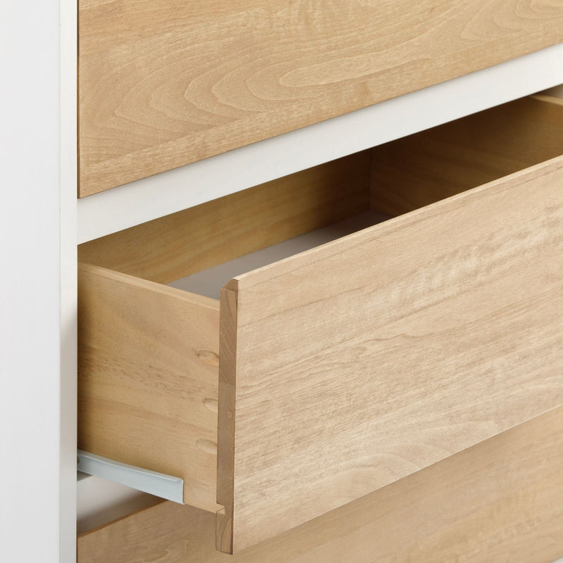 Close-up of light maple wood dresser drawers showing dovetail joinery, wood grain texture, and metal drawer slides in a modern white cabinet