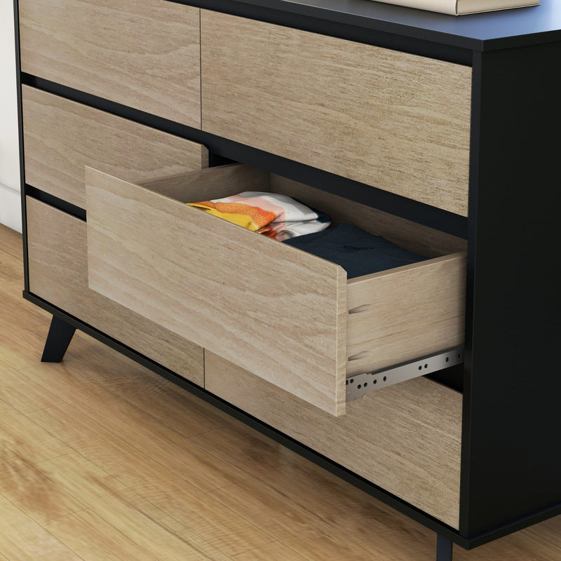 Modern two-tone wooden dresser with an open drawer showing folded clothes, black frame and tapered legs on hardwood floor — bedroom storage dresser organizer