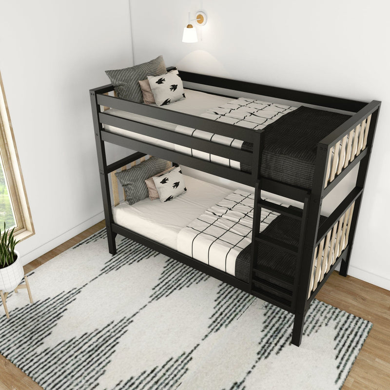 Modern black metal twin bunk bed with patterned bedding, pillows and ladder in a bright kids' bedroom