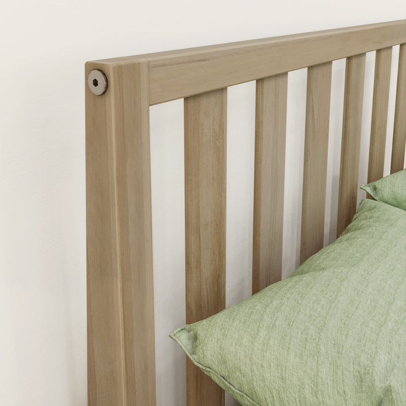 Light oak slatted wooden headboard with vertical slats and sage green pillow in a minimalist bedroom