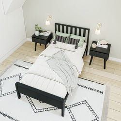 Stylish minimalist bedroom with black bed, white bedding, matching nightstands, and geometric rug.