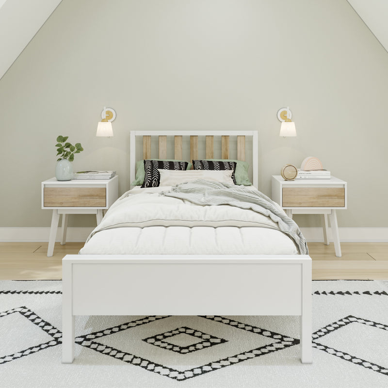 Minimalist Scandinavian bedroom with white platform bed, slatted wood headboard, green accent pillows, matching nightstands, wall sconces and black-and-white patterned rug