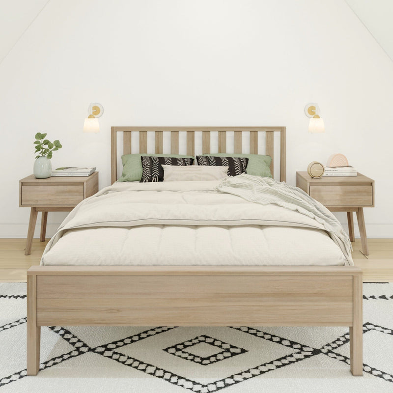 Minimalist bedroom with light wood bed frame, neutral linen bedding, green accent pillows, wooden nightstands and wall sconces on patterned rug