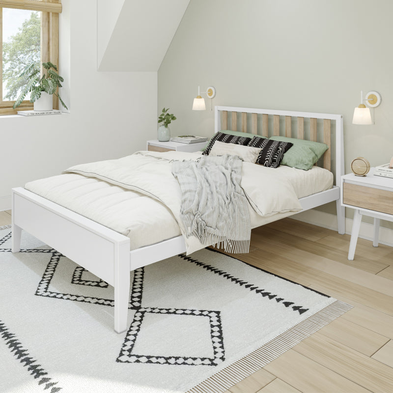 Minimalist Scandinavian bedroom with white wooden bed, green bedding, patterned black-and-white rug, wooden nightstands, wall sconces and natural window light
