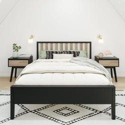 Modern bedroom with a stylish black bed frame and matching nightstands, featuring minimalist decor and a geometric patterned rug.