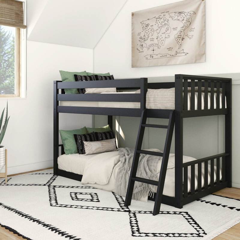 Black wooden bunk bed with ladder in modern kids' bedroom, green throw pillows and beige bedding, world map wall art, white geometric rug and natural window light