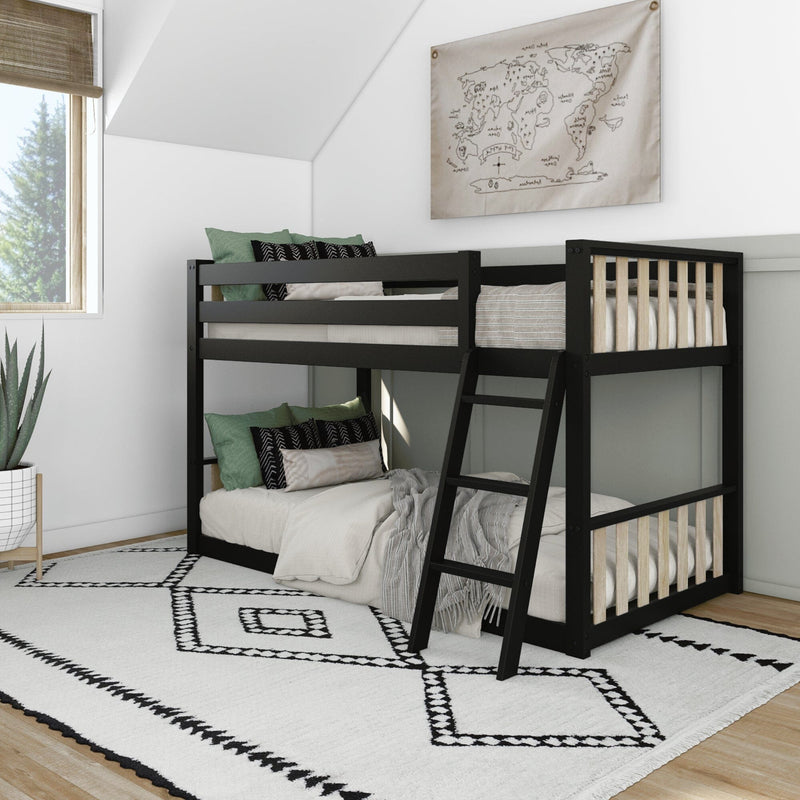 Black wooden bunk bed with ladder in bright modern kids' bedroom, green accent pillows, white geometric rug, potted plant and world map wall art