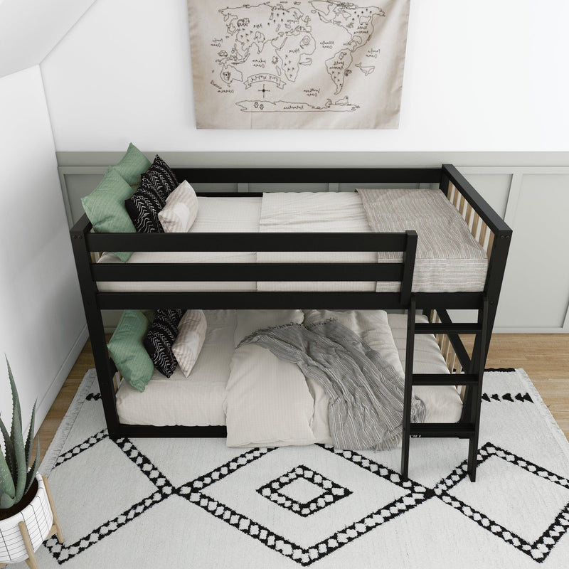 Black metal bunk bed with ladder in modern kids' room, white bedding, green accent pillows, map wall art and geometric rug