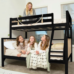 Black wooden bunk bed with ladder in bright kids' bedroom, three children lounging on the lower bed and one on the top bunk with neutral bedding and decorative garland