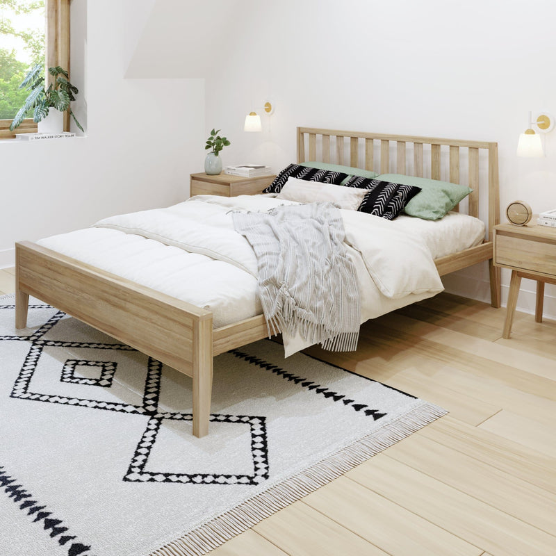 Minimalist Scandinavian bedroom with light-wood platform bed, white bedding, black-and-white geometric rug, wooden nightstands, wall sconces and potted plant by window