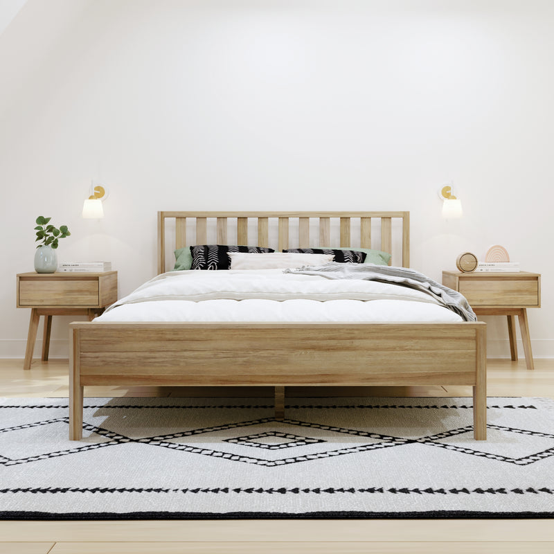 Minimalist Scandinavian bedroom with light wood slatted bed frame, white bedding, matching bedside tables, wall sconces, potted plant, and patterned black-and-white rug