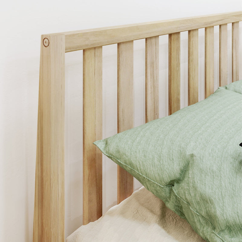 Light oak slatted wooden bed headboard with green linen pillow and beige bedding in a minimalist bedroom interior