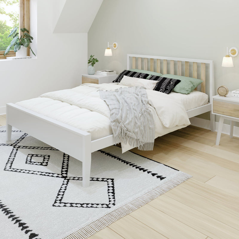 Minimalist Scandinavian bedroom interior with white wooden bed, light wood headboard, cozy neutral bedding, patterned rug, wall sconces and potted plant