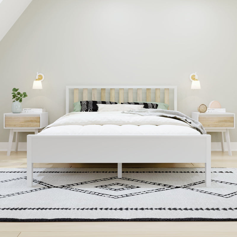 Minimalist Scandinavian bedroom with white wooden bed and slatted headboard, matching nightstands, wall sconces, green plant, bedside clock and black-and-white geometric rug
