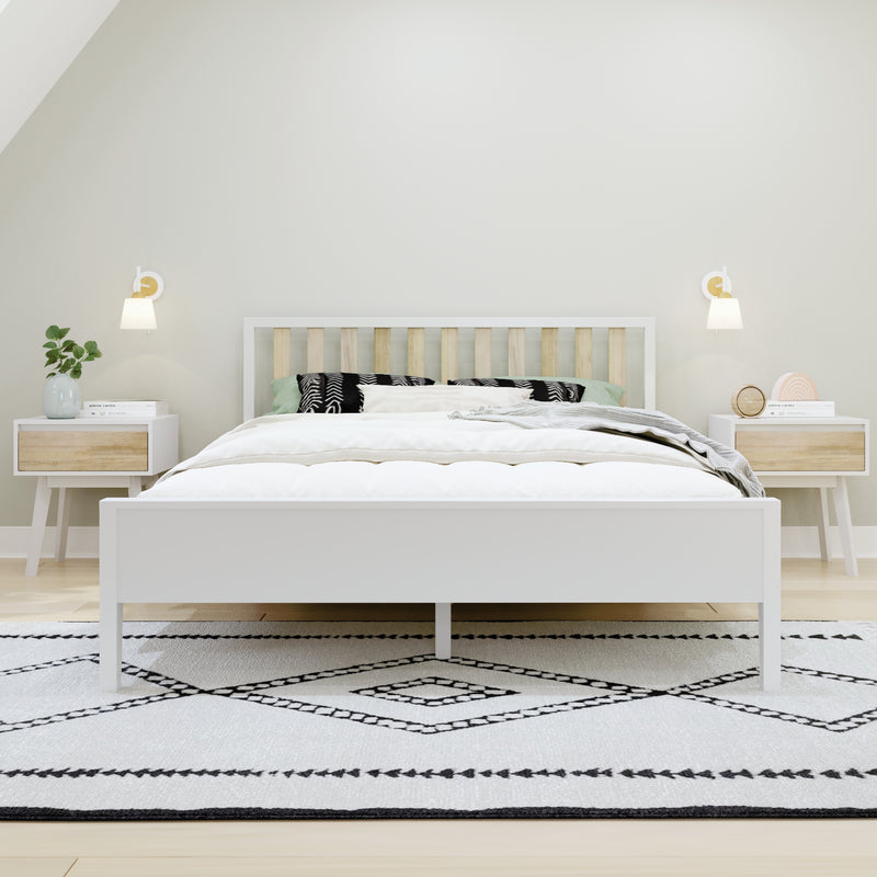 Minimalist Scandinavian bedroom interior with white wooden bed and slatted headboard, neutral layered bedding, black-and-white geometric rug, matching nightstands with wall sconces and potted plant