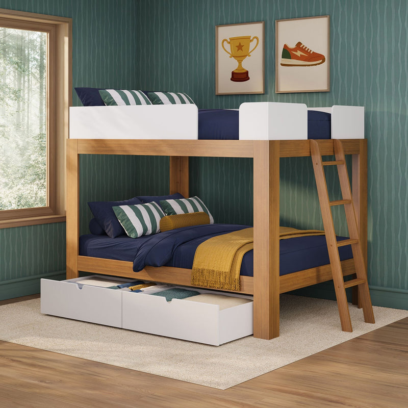 Modern wooden bunk bed with navy bedding, green striped pillows and under-bed storage drawers in a children's bedroom with teal textured wallpaper, ladder and framed trophy and sneaker prints beside a large window overlooking a forest.