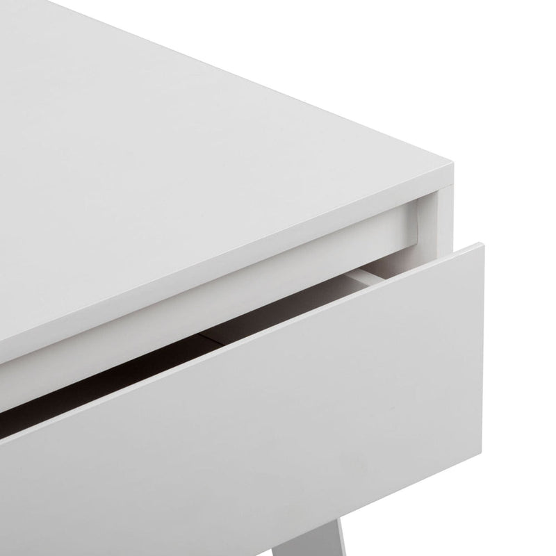 Close-up of a white modern handleless nightstand drawer showing minimalist bedside table design, matte finish and clean lines