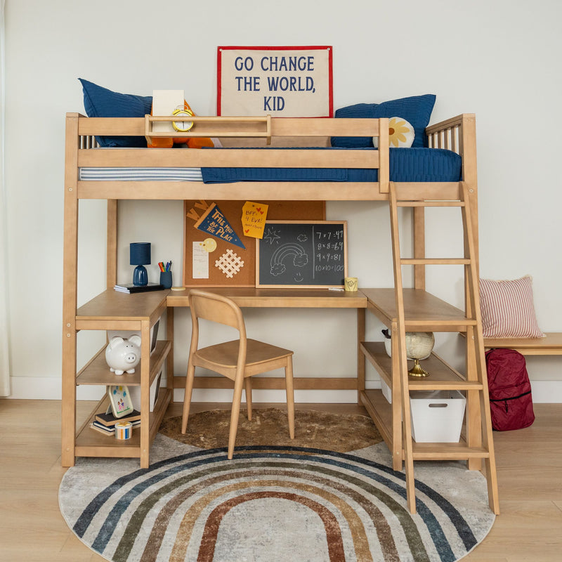 Wooden kids loft bed with built-in desk and shelves, ladder, blue bedding, study nook, round rainbow rug and "Go Change the World, Kid" wall art