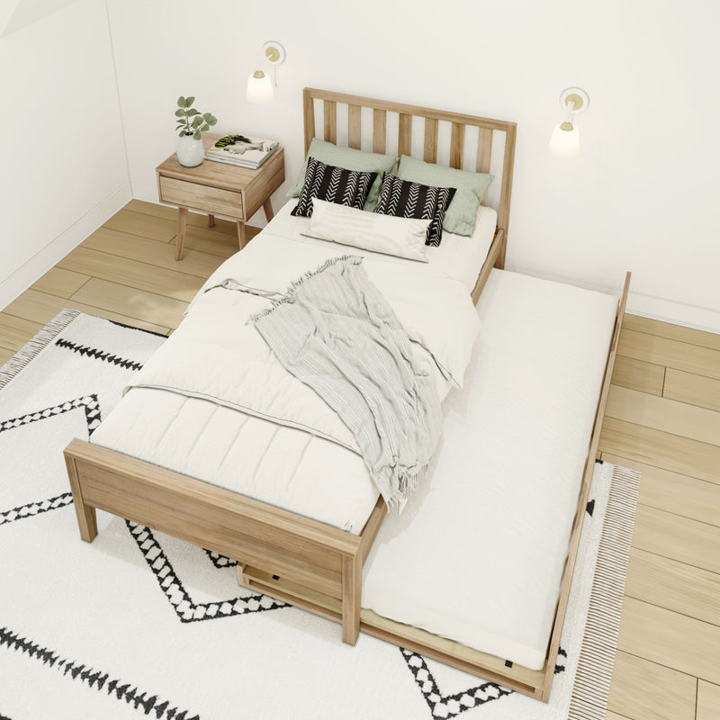 Scandinavian minimalist bedroom with wooden slat bed and pull-out trundle, white bedding and patterned pillows, wooden nightstand with plant and magazine, modern wall sconces, neutral boho rug