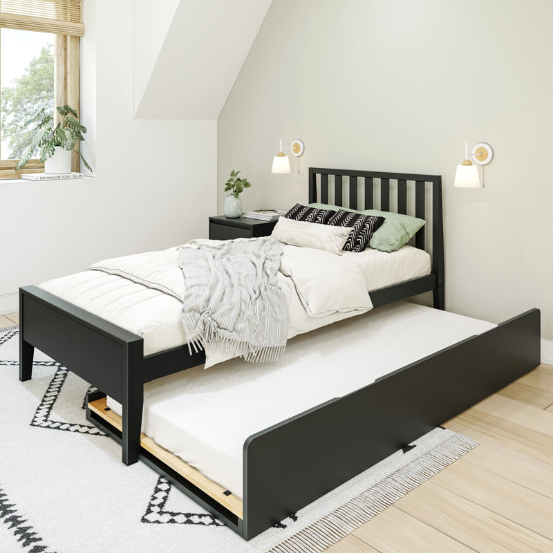 Minimal Scandinavian bedroom with black wooden trundle bed, white bedding, black-and-white patterned pillows and rug, wall sconces and potted plant by sunlit window
