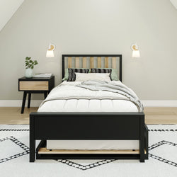 Modern bedroom with black bed frame, matching nightstand, and geometric rug.