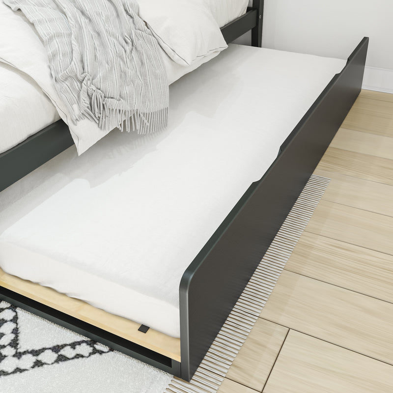 Modern dark wood bed with pull-out trundle mattress, white linens and gray tasseled throw on light hardwood floor