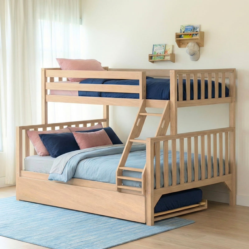 Light wood bunk bed with ladder and trundle in airy kids' bedroom with navy bedding, pink pillows, and wall-mounted bookshelves