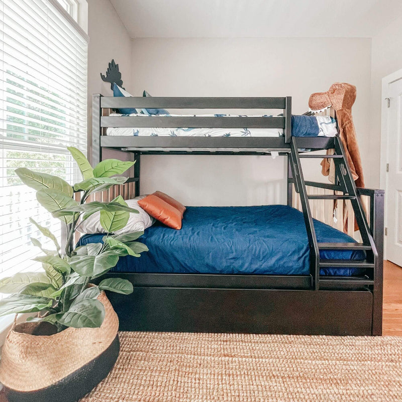 Children's room with black wooden bunk bed, navy bedding and orange accent pillows, dinosaur stuffed animal on ladder, large potted plant and sunlit window blinds