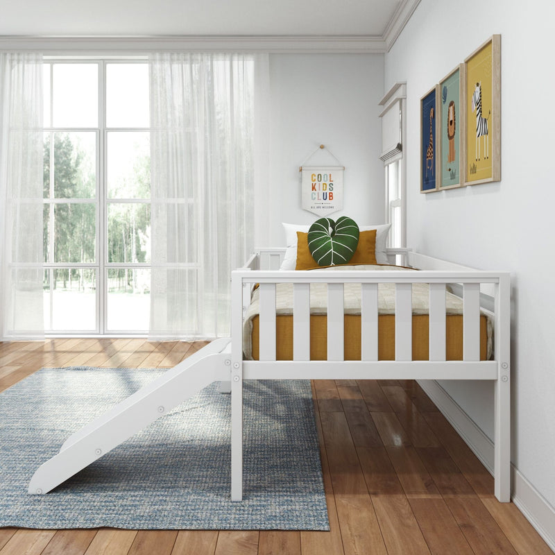 Modern minimalist nursery with white toddler bed, large sunlit window, mustard pillows and green leaf cushion, framed animal wall art