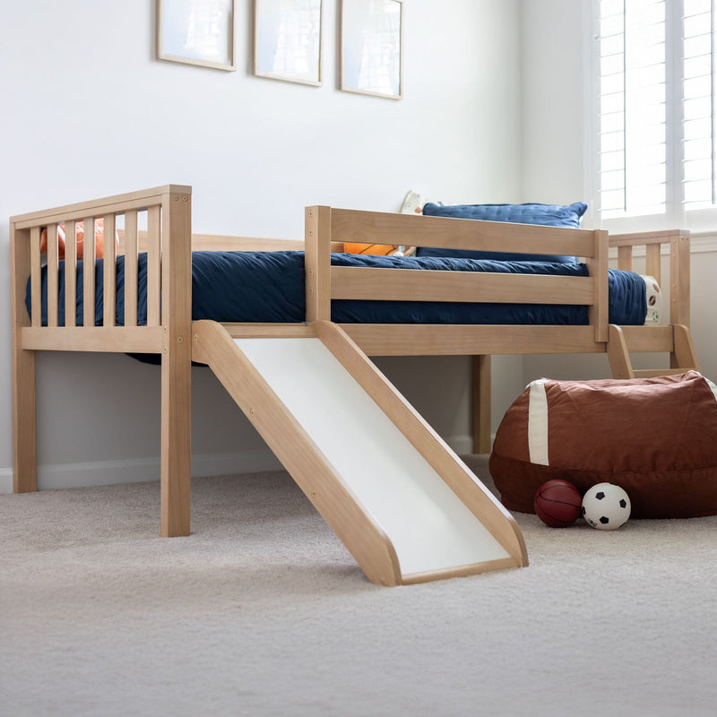 Natural wood kids loft bed with slide and navy bedding in a bright children's bedroom with sports beanbag and toy balls
