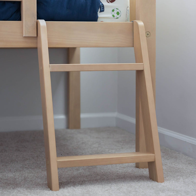 Close-up of a natural light-wood bunk bed ladder and guardrail in a children's bedroom with navy bedding and soccer-print sheets on a carpeted floor