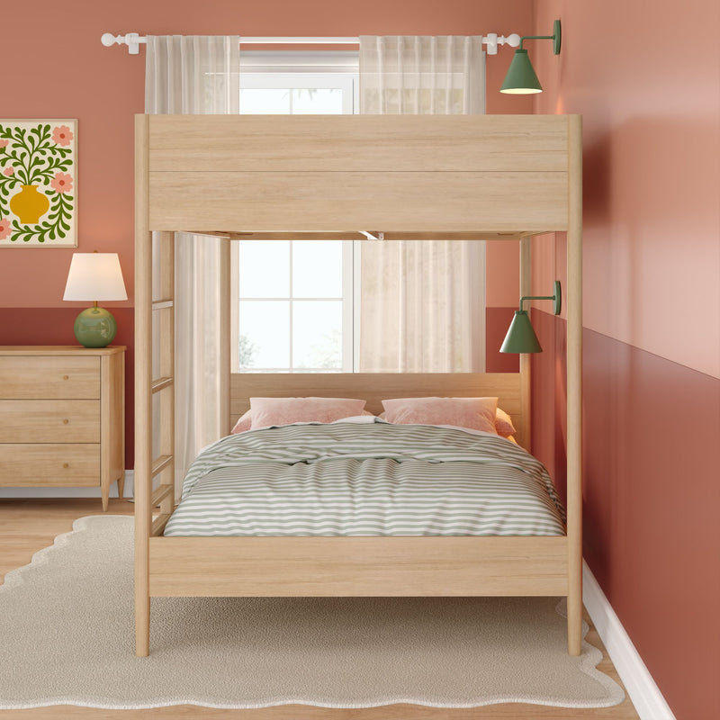 Light wood Scandinavian bunk bed in cozy kids' bedroom with striped duvet, pink pillows, green wall sconces, coral accent wall, wooden dresser and window light