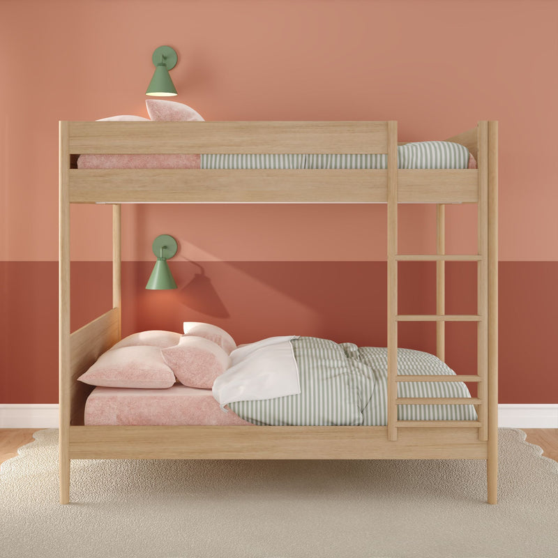 Modern natural wood bunk bed in kids' bedroom with coral pink walls, green wall sconces, ladder, pastel pink pillows and green-striped bedding