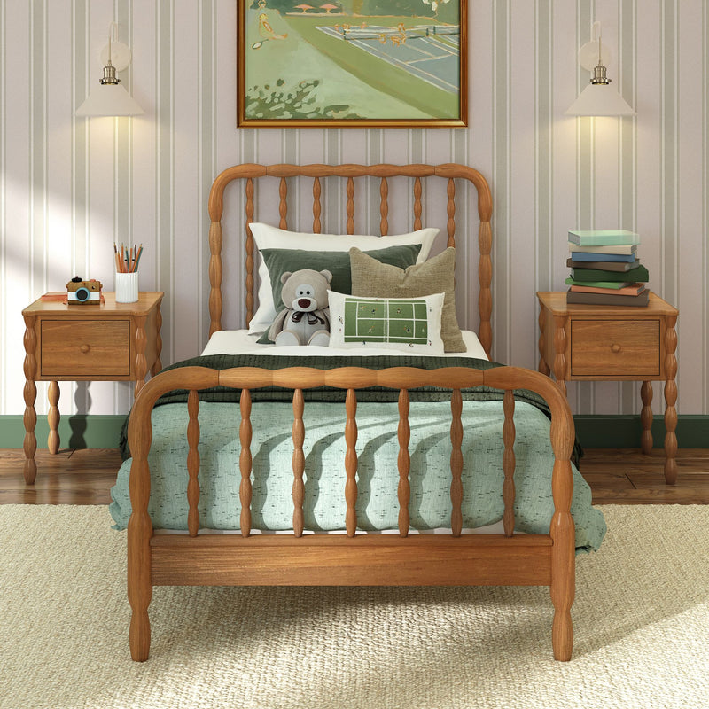 Cozy kids bedroom with wooden spindle bed, green bedding and teddy bear, matching wooden nightstands with stacked books and wall lamps, striped wallpaper and framed art