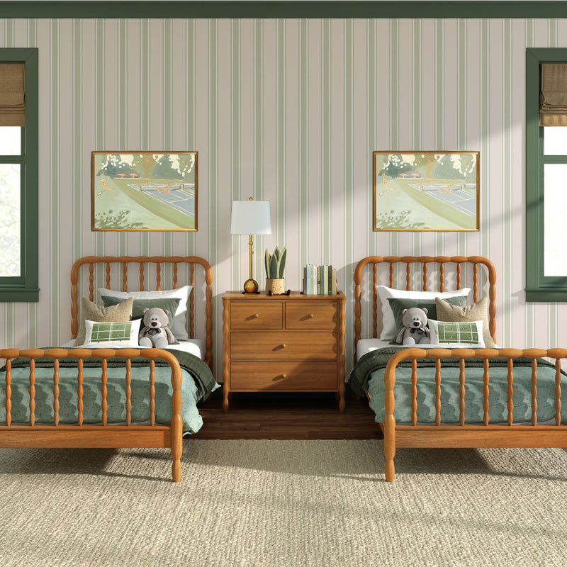 Cozy kids' bedroom interior with matching wooden spindle twin beds, green bedding and pillows, stuffed teddy bears, striped wallpaper, framed artwork and a wooden nightstand with lamp and plant