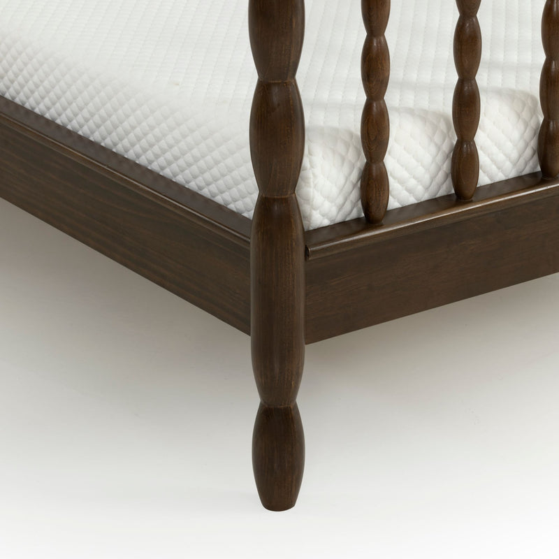 Close-up of dark wood spindle bed frame corner with white quilted mattress — traditional farmhouse bedroom furniture