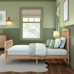 Mint green children's bedroom with wooden spindle bed, striped and patterned bedding, plush toys, roman shade window and wooden dresser