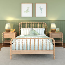 Light-wood spindle bed with striped green-and-white bedding in a sage nursery, matching nightstands and lamps, coastal wall art and plush toy.