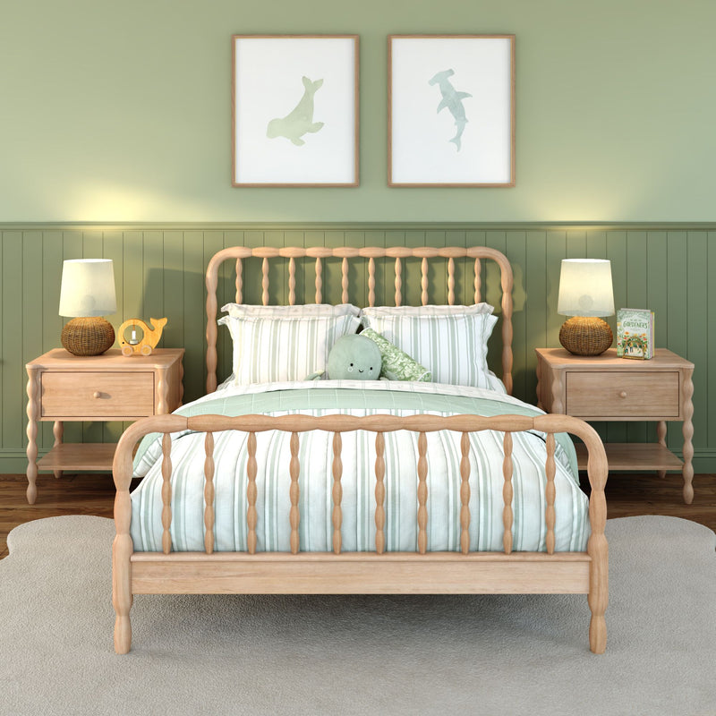 Light-wood spindle bed with striped green-and-white bedding in a sage nursery, matching nightstands and lamps, coastal wall art and plush toy.