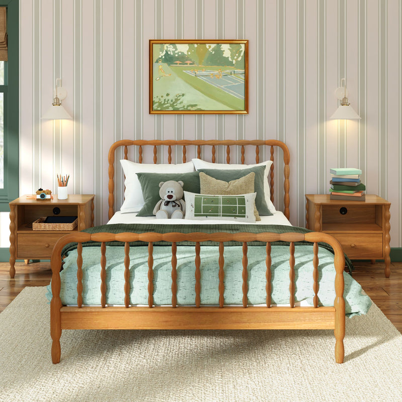 Cozy children's bedroom with wooden spindle bed, green bedding and pillows, teddy bear, striped wallpaper, framed art and bedside tables with lamps
