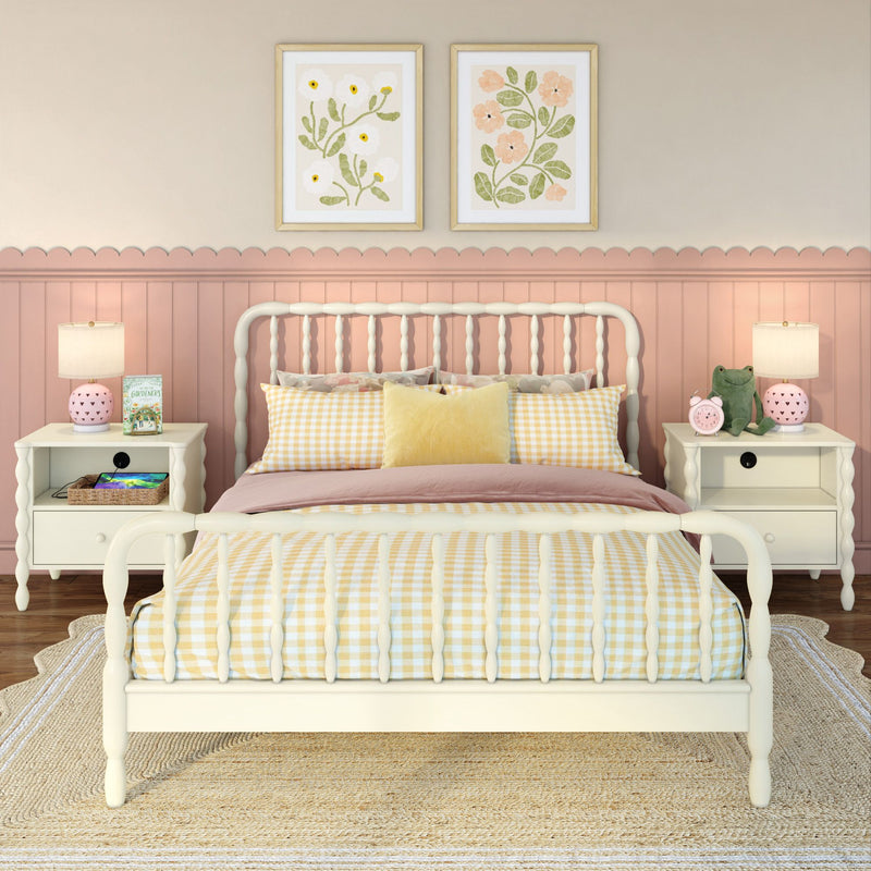Cozy pastel pink children's bedroom with white spindle bed, yellow gingham bedding, scalloped wainscoting, matching white nightstands, floral wall art, bedside lamps and stuffed frog toy