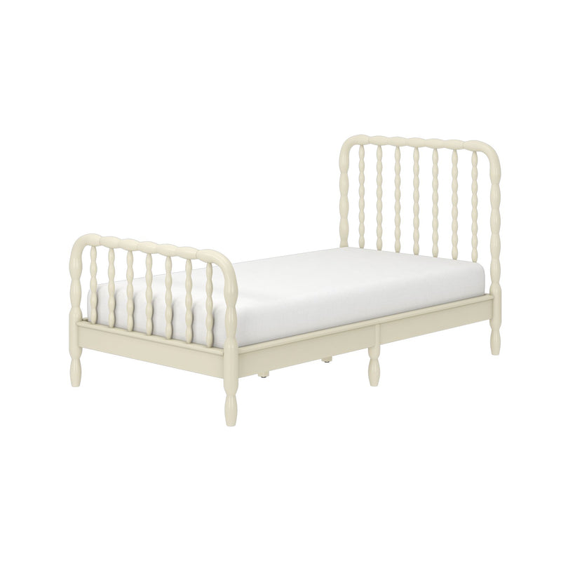 Cream spindle twin daybed with turned wooden legs and white mattress in a vintage farmhouse style