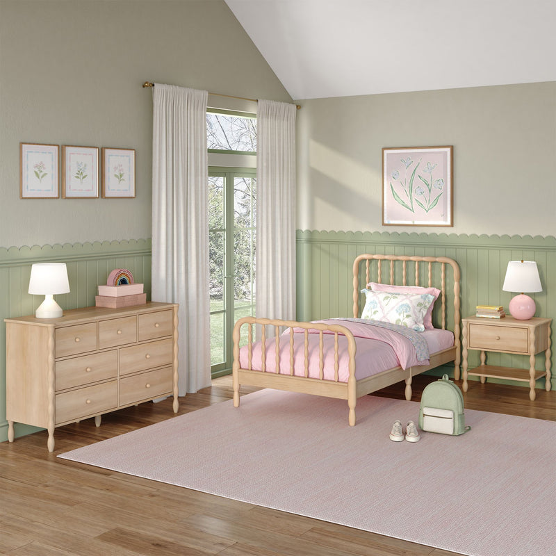 Pastel pink and sage green children's bedroom with wooden twin bed, scalloped wainscoting, dresser, bedside lamps, floral wall art and curtains