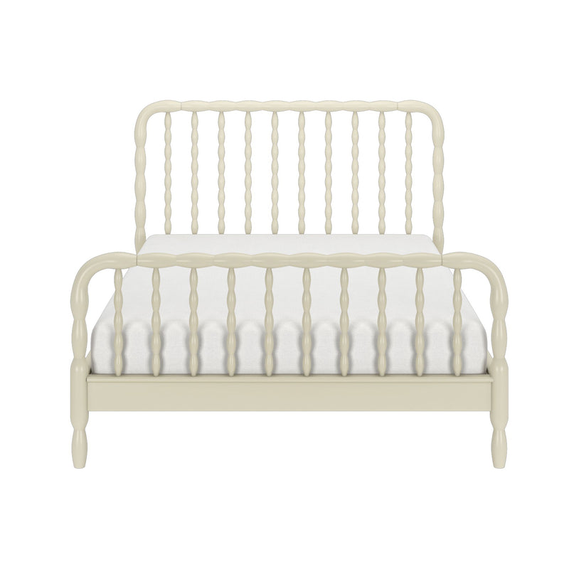 Ivory spindle bed frame with curved headboard and footboard and white tufted mattress on a plain white background