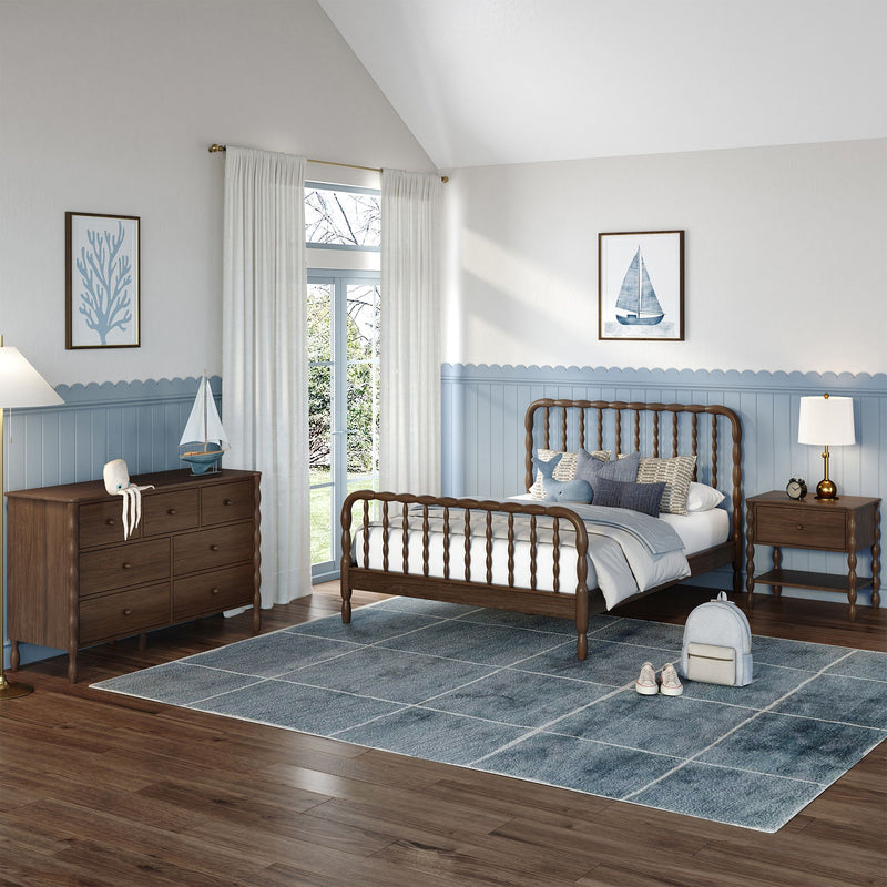 Coastal-themed kids bedroom with wooden spindle bed, light blue wainscoting, sailboat wall art, wooden dresser, plush octopus toy, and large blue area rug.